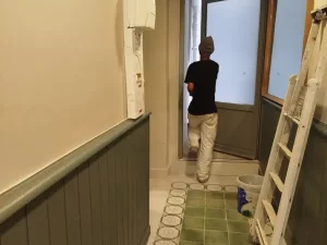 Un peintre se tient devant une porte ouverte à Pau